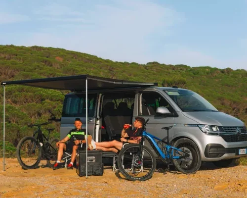Fiamma F40 Van Markise geöffnet am VW T6 – Camping Szene mit Camper Van, Outdoor Markise und Fahrrädern