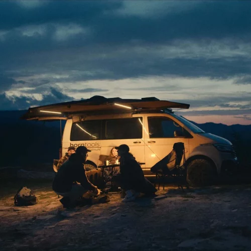Horntools 180 Grad Markise Horizon mit integrierter LED-Beleuchtung bei Nacht an einem Campervan aufgebaut.